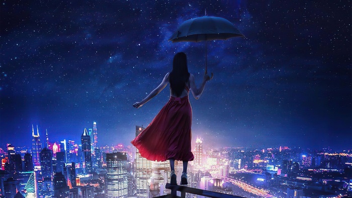 Woman in red dress with umbrella overlooking city at night