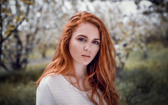 Redhead girl in white sweater outdoors