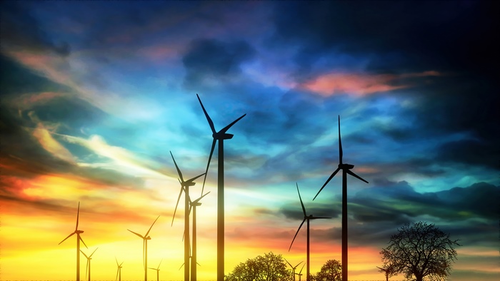Windmills silhouetted against a colorful sunset sky