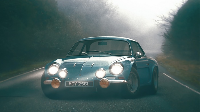 Blue Alpine car on a foggy road