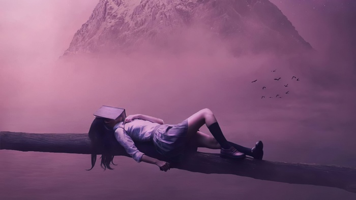 Girl sleeping on a log with a book over her face