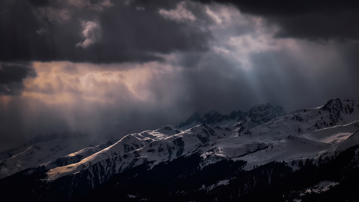 Snowy mountains under dramatic storm clouds