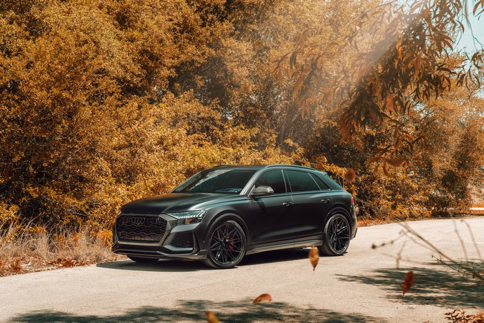 Audi RS Q8 SUV parked on a road with autumn trees