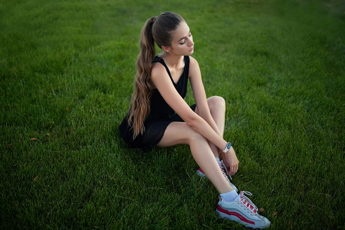 Young Woman Sitting on Grass in 4K