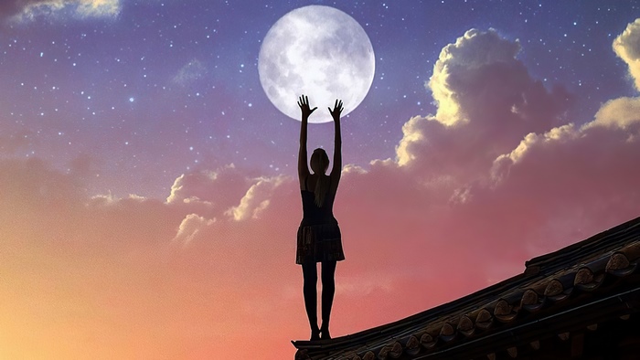 Woman reaching for the moon on a rooftop
