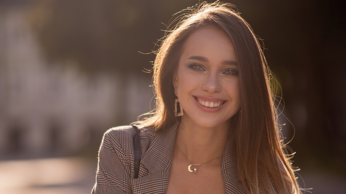 Young woman smiling in a plaid jacket