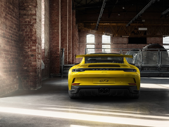 Yellow Porsche GT3 in industrial building
