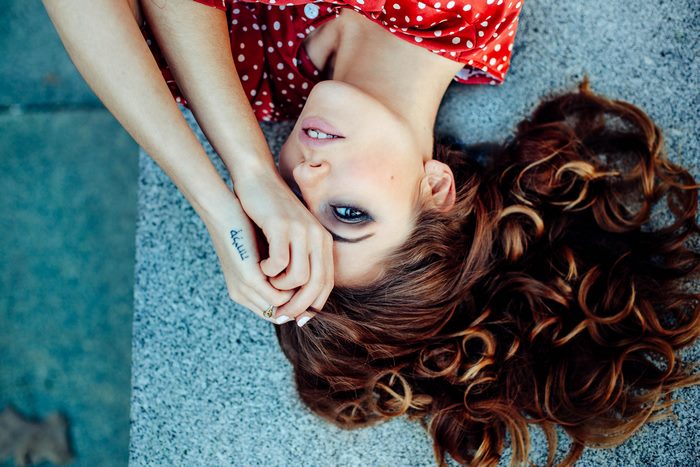 Girl with red polka dot dress lying down