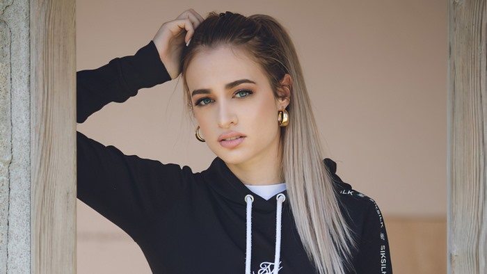 Blonde model wearing a black hoodie