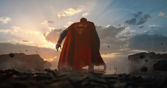 Superman standing in water at sunset
