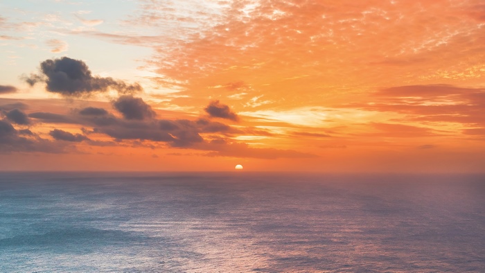Sunset over the ocean with clouds