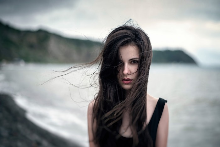 Girl with dark hair by the sea