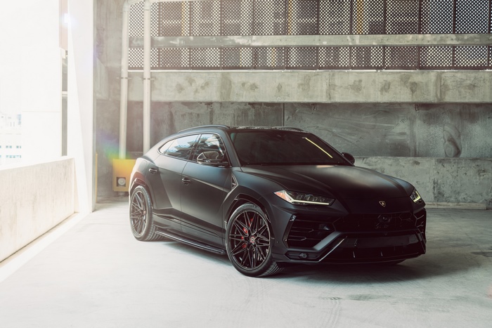 Matte black Lamborghini Urus parked in a concrete structure