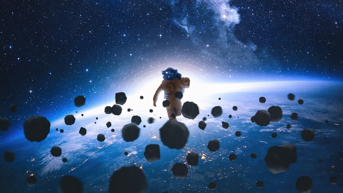 Astronaut floating in space with asteroids and Earth below