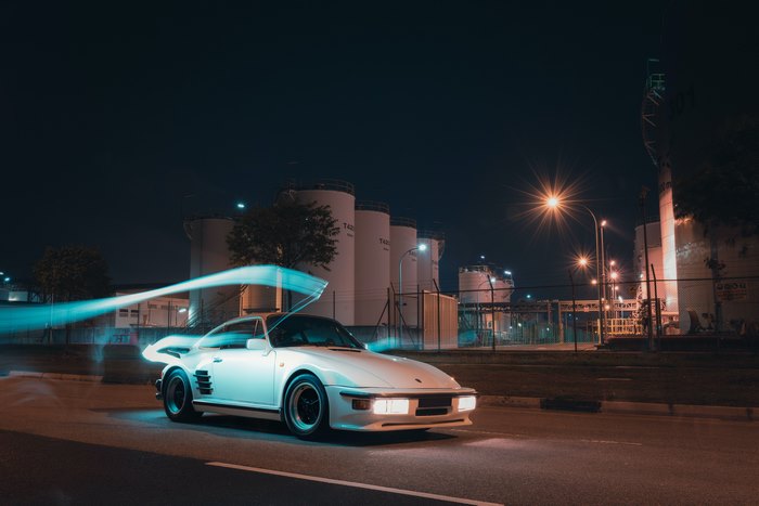 White Porsche 911 with light trails at night