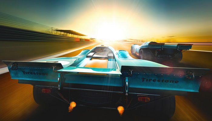 Two racing cars on a track at sunset