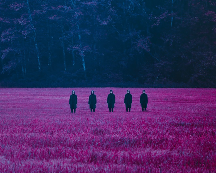 Five figures in black robes in a pink field