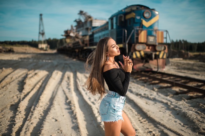Model in denim shorts and black top near train