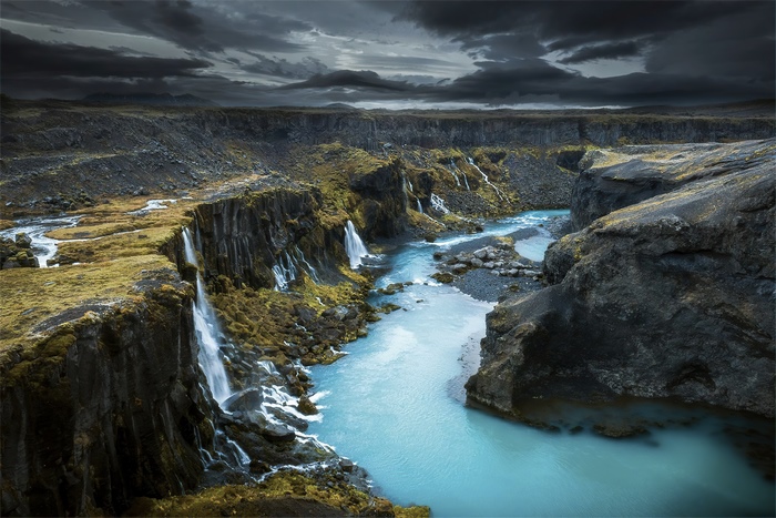 Icelandic River with Waterfalls Under Cloudy Sky