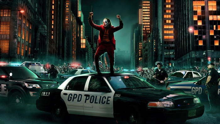 Joker standing on police car in city street