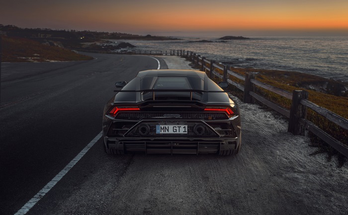 Black Lamborghini Huracan GT 1 on coastal road at sunset