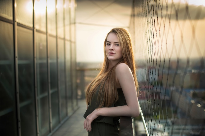 Young woman with long blonde hair on a balcony