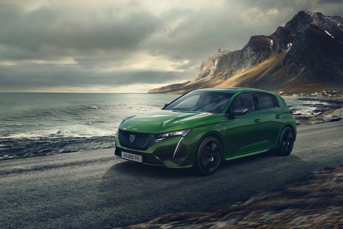 Green Peugeot 308 driving on a coastal road