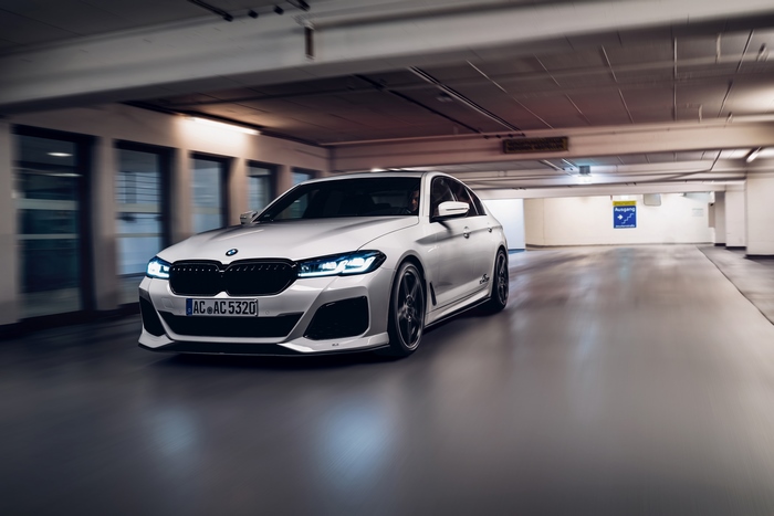 White BMW M5 in a parking garage