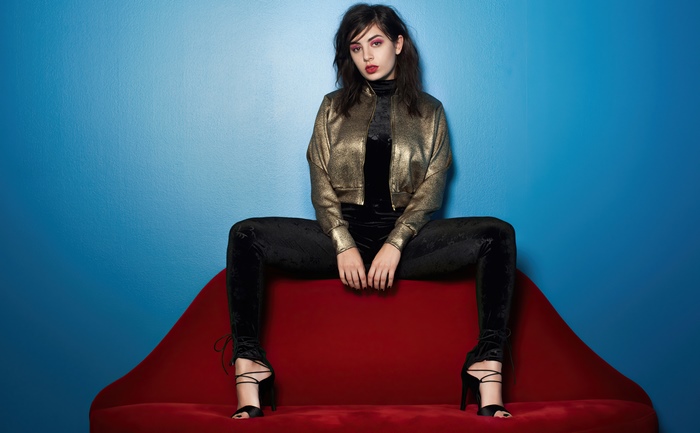 Charli XCX on a red couch