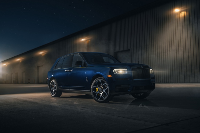 Rolls Royce Cullinan parked outside a warehouse at night