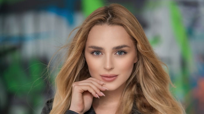 Blonde model posing in front of graffiti wall