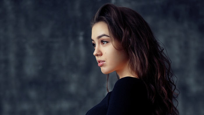 Model with dark hair in black top