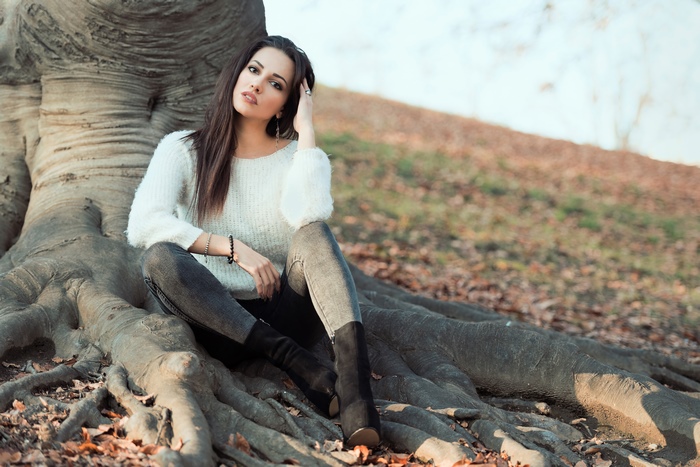 Brunette Model Sitting on Tree Roots in Nature