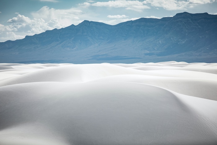 White sand dunes with mountains in the background