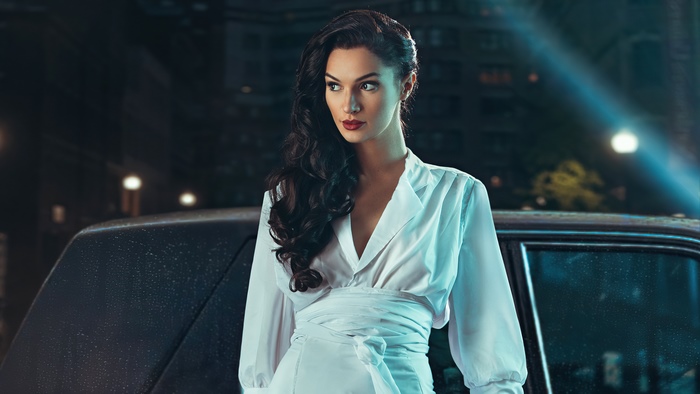 Wonder Woman in white dress by a car at night