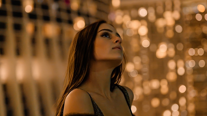 Woman looking up at bokeh lights