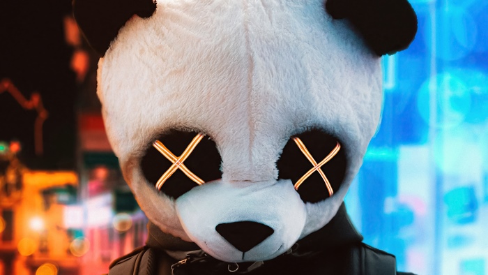 Panda mask with glowing X eyes in city at night