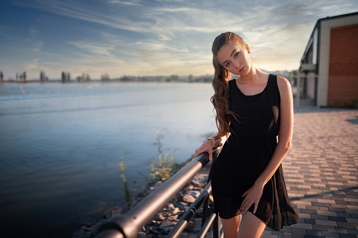 Girl in black dress by the water