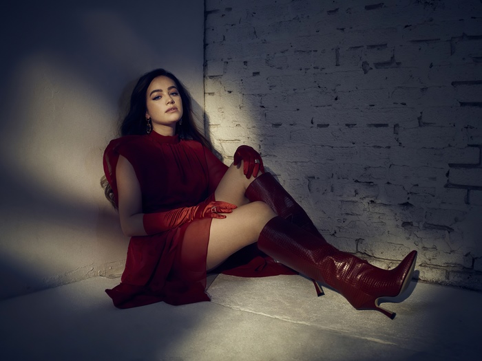Mary Mouser in a red dress and boots