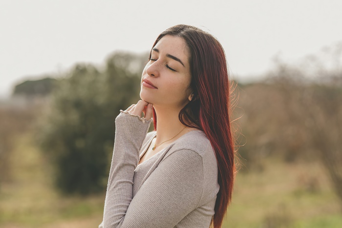 Redhead girl with eyes closed outdoors