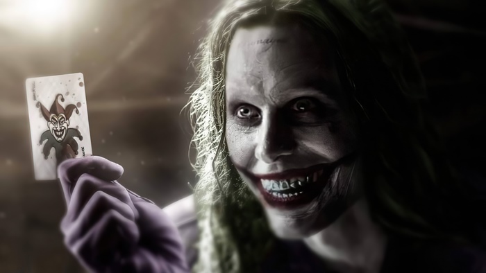 Jared Leto as Joker holding a Joker card