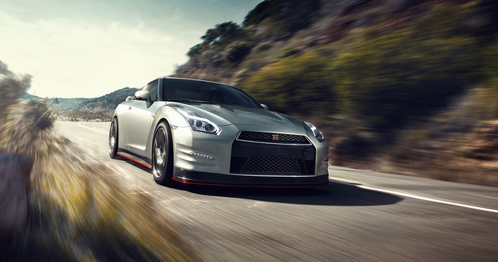 Silver Nissan GT-R driving on a mountain road