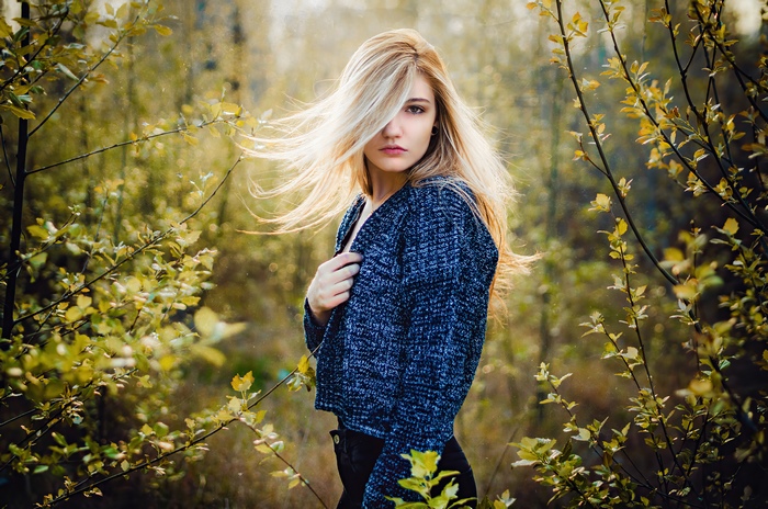 Blonde girl in a blue sweater in nature