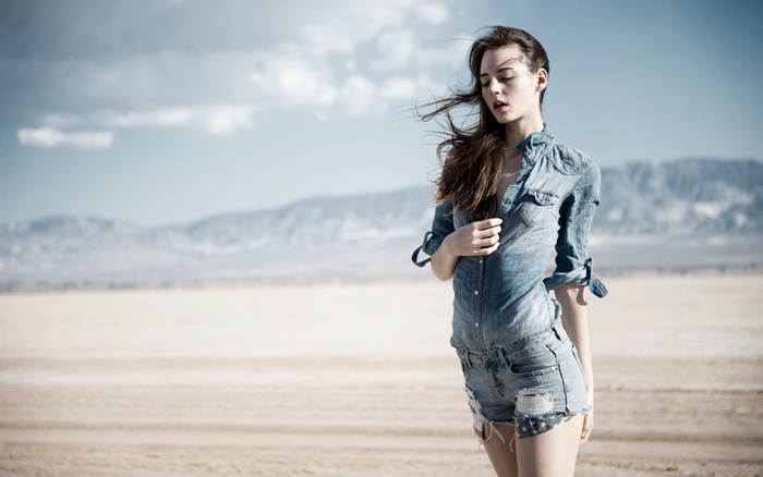 Model in denim shorts and shirt in desert