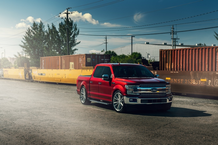 Red Ford F-150 Truck near Shipping Containers