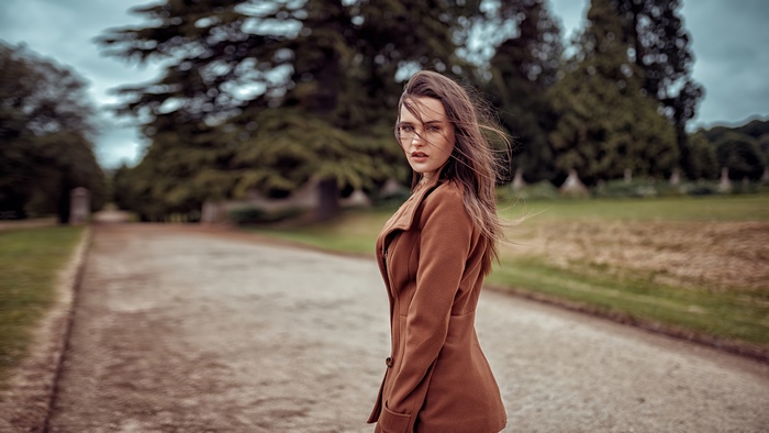 Woman in brown coat in park