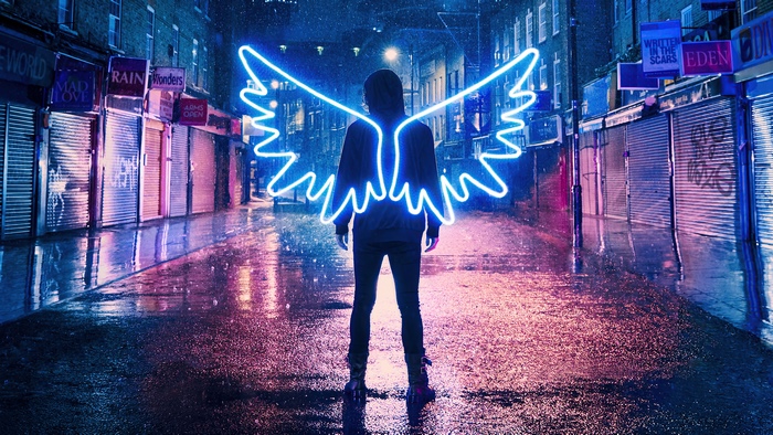 Person with neon angel wings in a rainy city alley