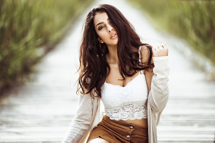 Model in white top and brown skirt on path