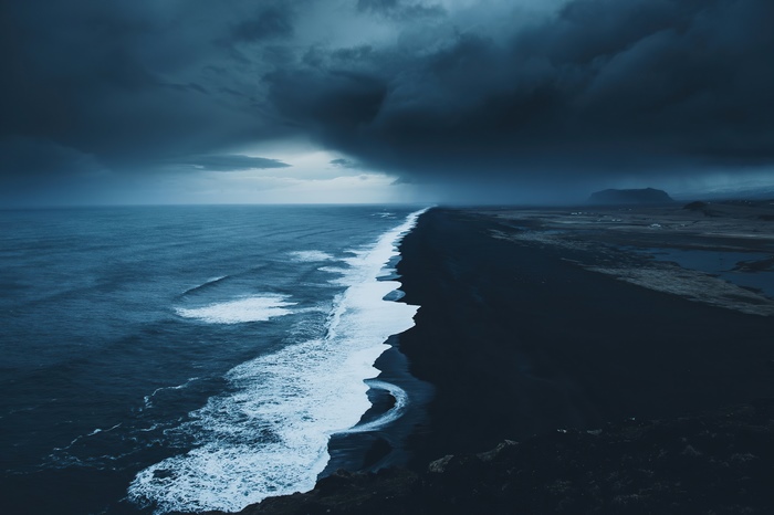 Dark stormy ocean waves crash on black sand beach in Iceland 4K