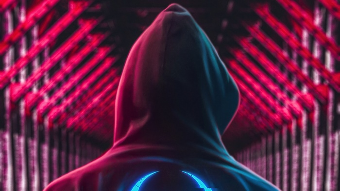 Person in a hoodie with a glowing symbol